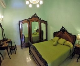A private guesthouse room in Havana with some fancy furniture.