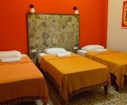 The Orange room has 3 single beds The Orange Room of La Gargola Hostal in Old Havana, Cuba